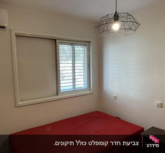 קיר צבוע בלבן עם מנורה תלויה